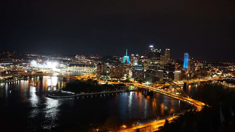 Panoramic Pittsburgh night skyline with glowing bridges and river lights