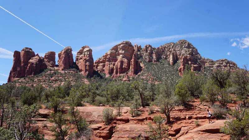 Hiker on trail with iconic Sedona red rock formations in background